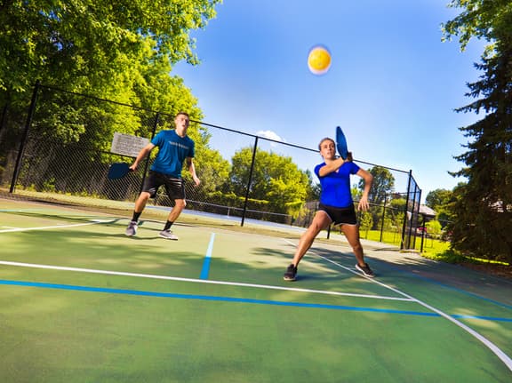 This is a photo of a man and a woman playing pickleball.