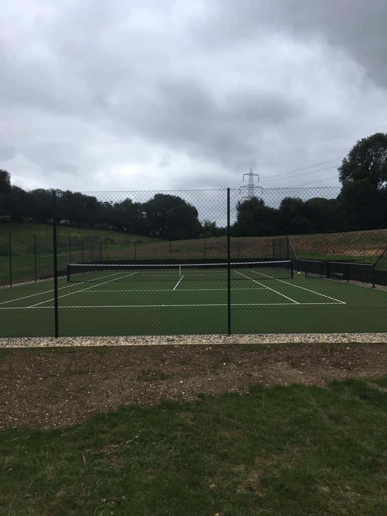 This is a photo of a new tennis court that has just been installed, along with new fencing and landscaping has been carried out too.