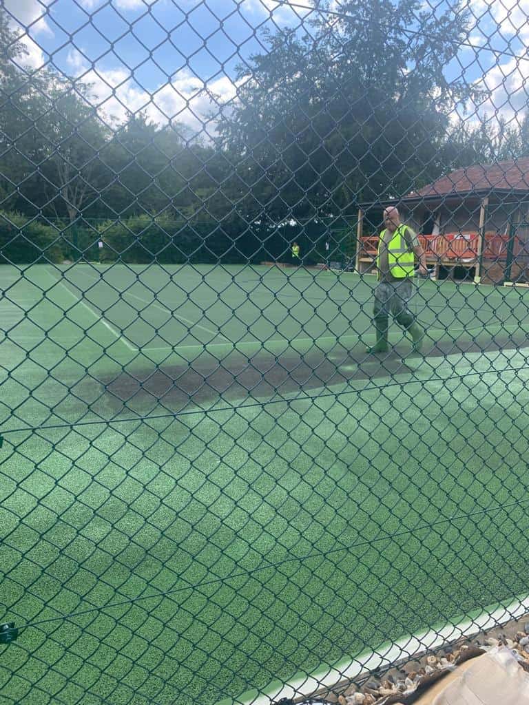 This is a photo of a tennis court being cleaned and prepared for a new coat